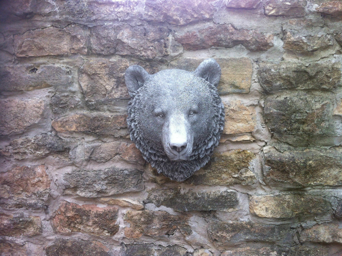 Full view of Stone Bear Head Wall Ornament centered on a garden stone wall, perfect as a wildlife-themed decorative plaque.