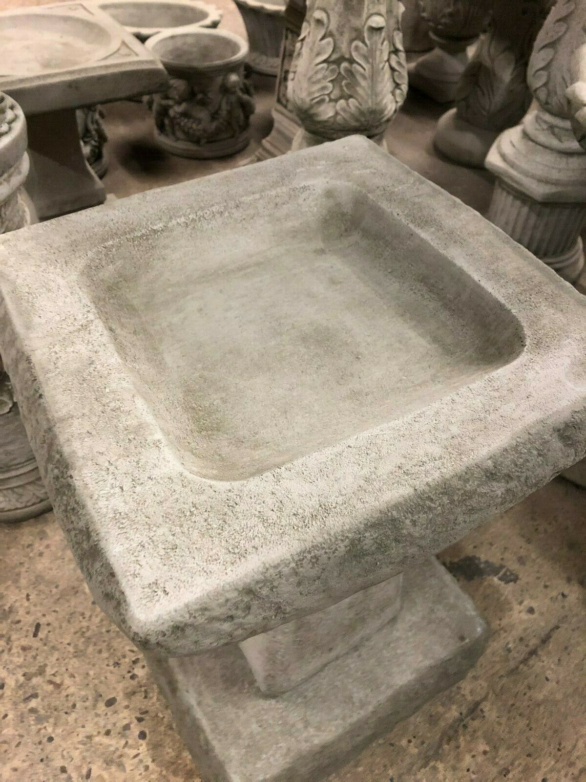 Top view of stone bird bath with deep square basin and rough antique texture. Perfect for attracting birds to your garden or patio.