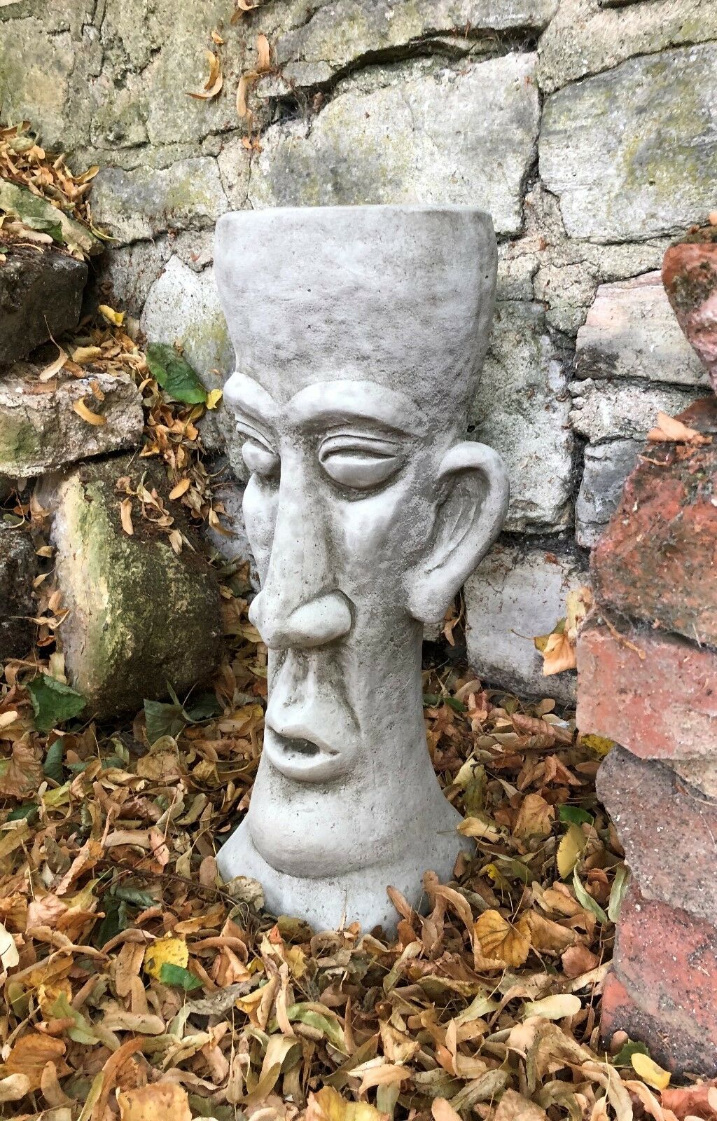 Angled view of the Stone Easter Island Head Planter highlighting its sculptural design and durable stone material for garden decoration.