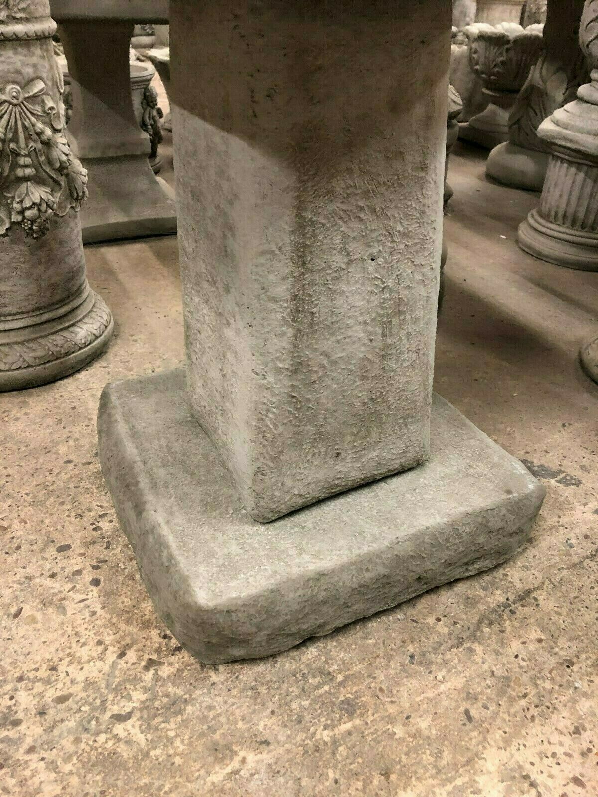 Close-up of the heavy limestone base of the chunky square bird bath. Designed for stability and long-lasting outdoor placement.