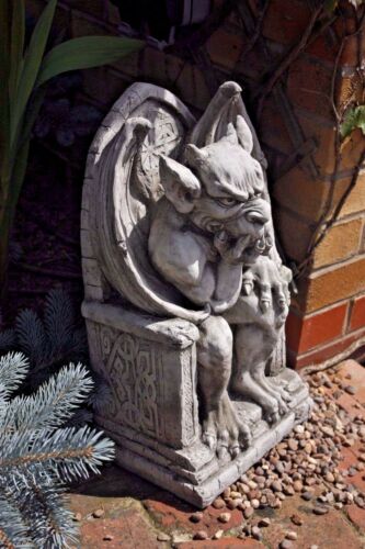 Angled view of King Gargoyle Stone Statue - Weather Resistant Garden Art near brick wall and pebbles, ideal for enhancing entryways or patios.
