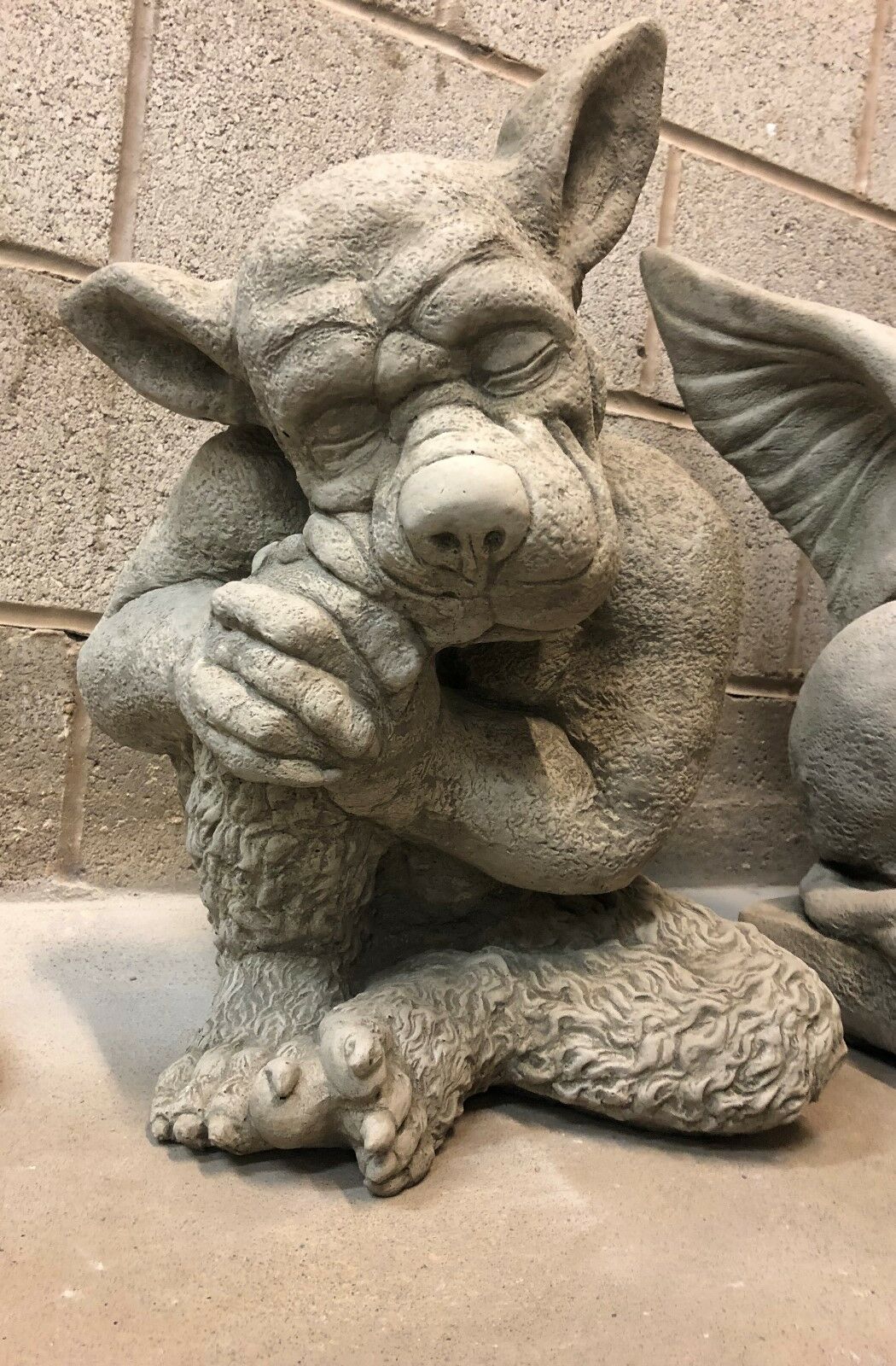 Front-facing Sleeping Dog Gargoyle Statue made of stone, perfect for adding mythical charm to patios or garden sculpture collections.