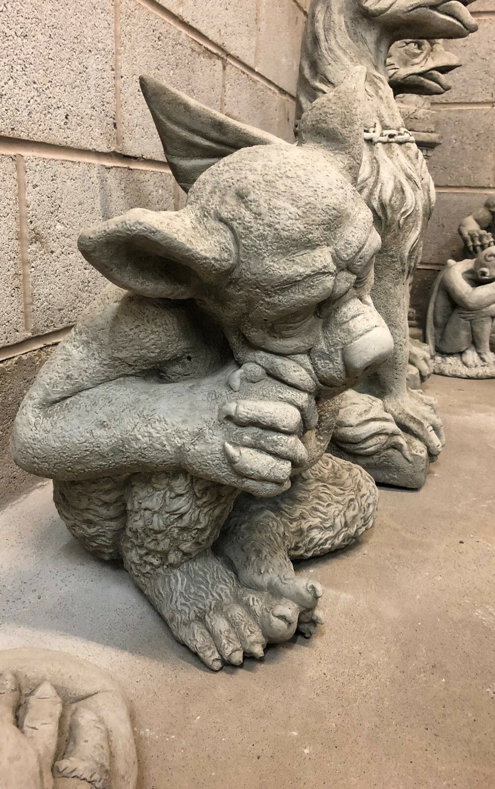 Angled view of Sleeping Dog Gargoyle Statue with folded arms and detailed paws, a solid stone garden sculpture for outdoor decor.