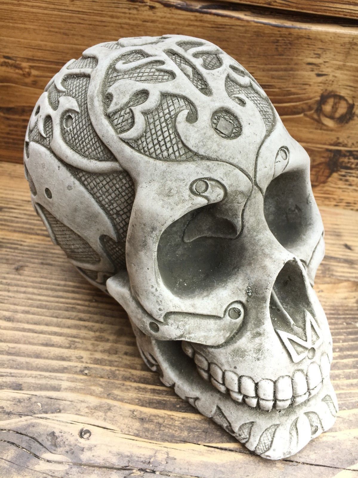 Stone Skull Garden Ornament with unique detailing on top and sides, made from durable limestone for outdoor decor in flowerbeds or patios.