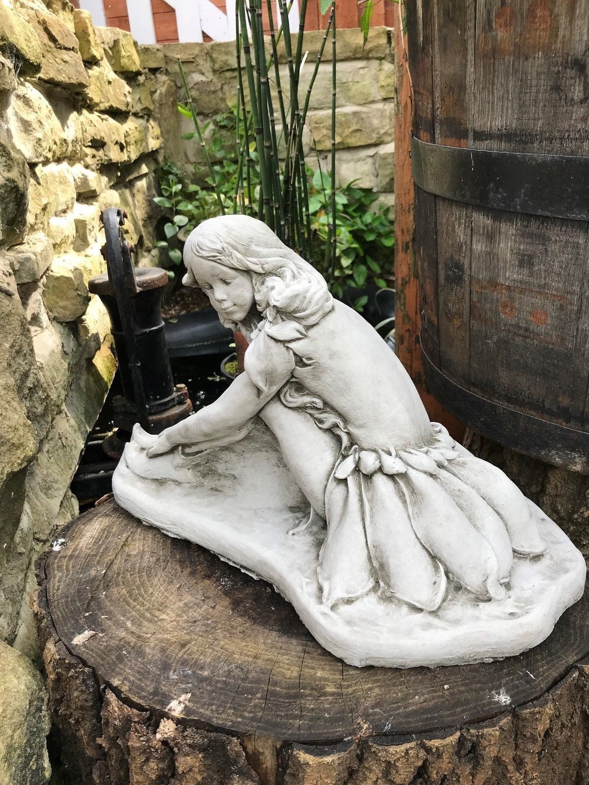 Rear view of a stone fairy garden sculpture highlighting the detailed wings and dress folds, crafted for UK garden decor.