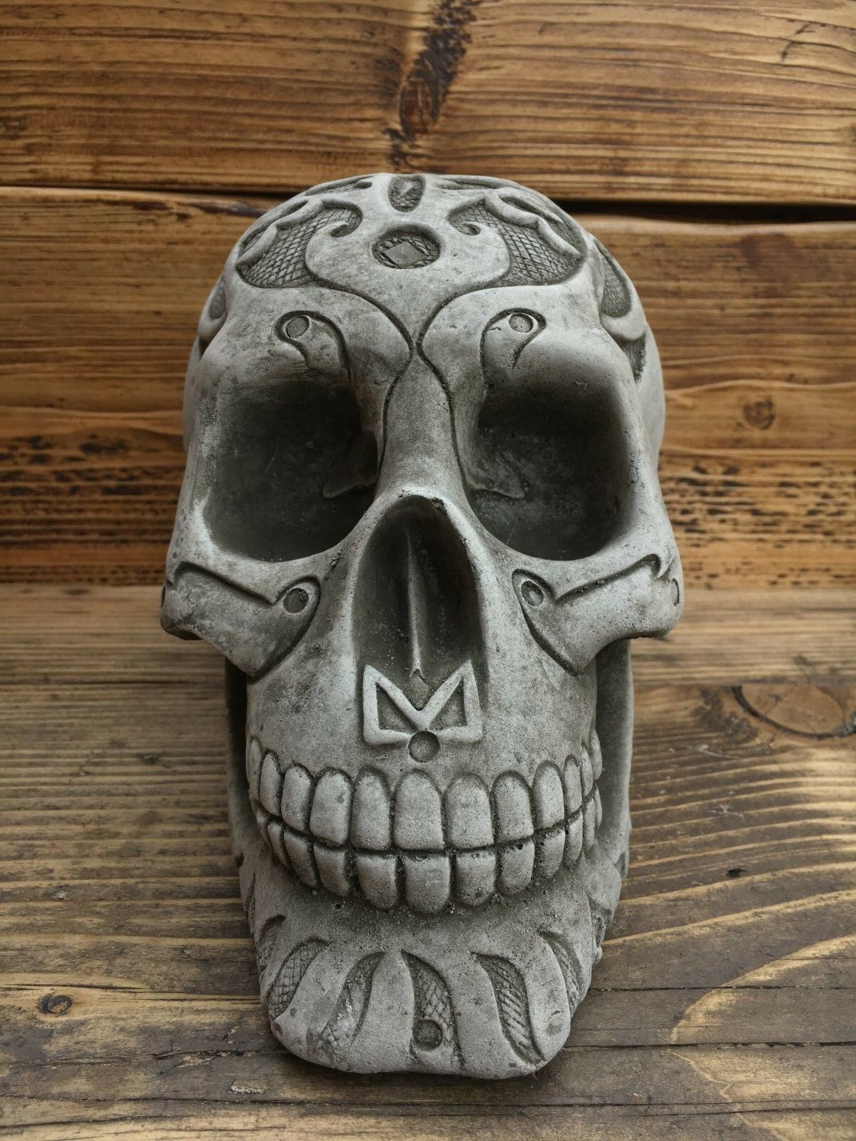 Front view of Stone Skull Garden Ornament featuring intricate carved patterns, ideal for gothic garden themes and weather-resistant landscaping.