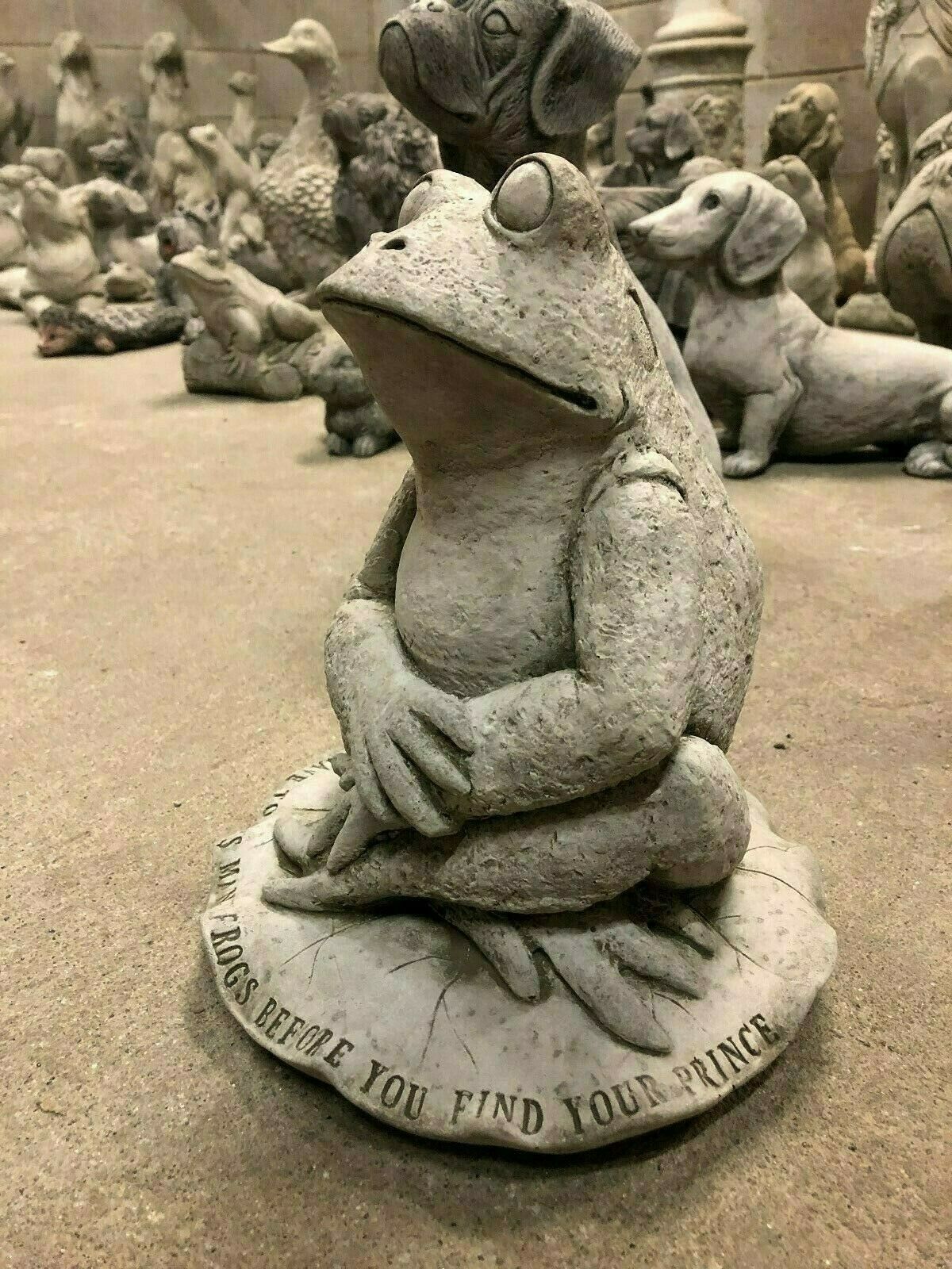 Stylish garden sculpture of a stone frog sitting on a lilypad with the phrase 'You have to kiss many frogs before you find your prince' engraved around the base.