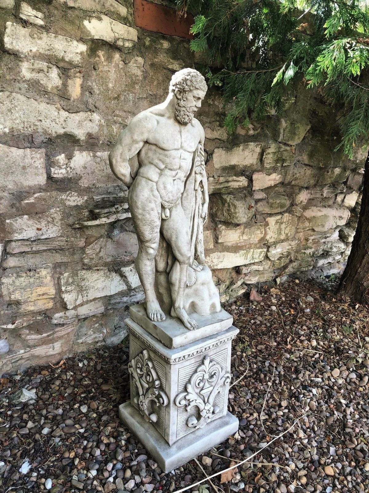 Hercules stone statue garden sculpture in limestone finish, featuring detailed lion skin and muscular form on ornate plinth.