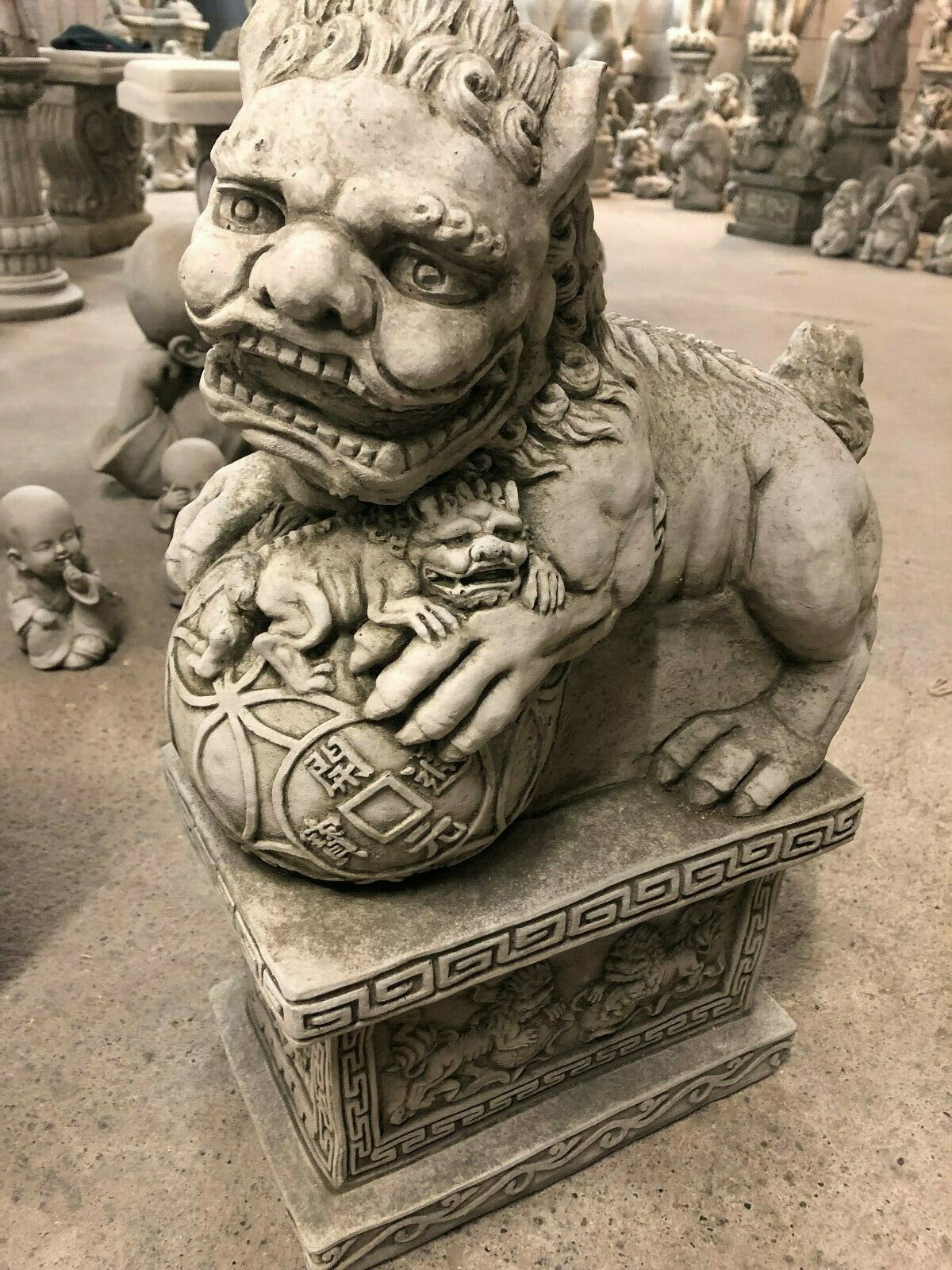 Front angle of Foo Dog Statue highlighting protective symbolism with cub detail and traditional Chinese coin carvings.