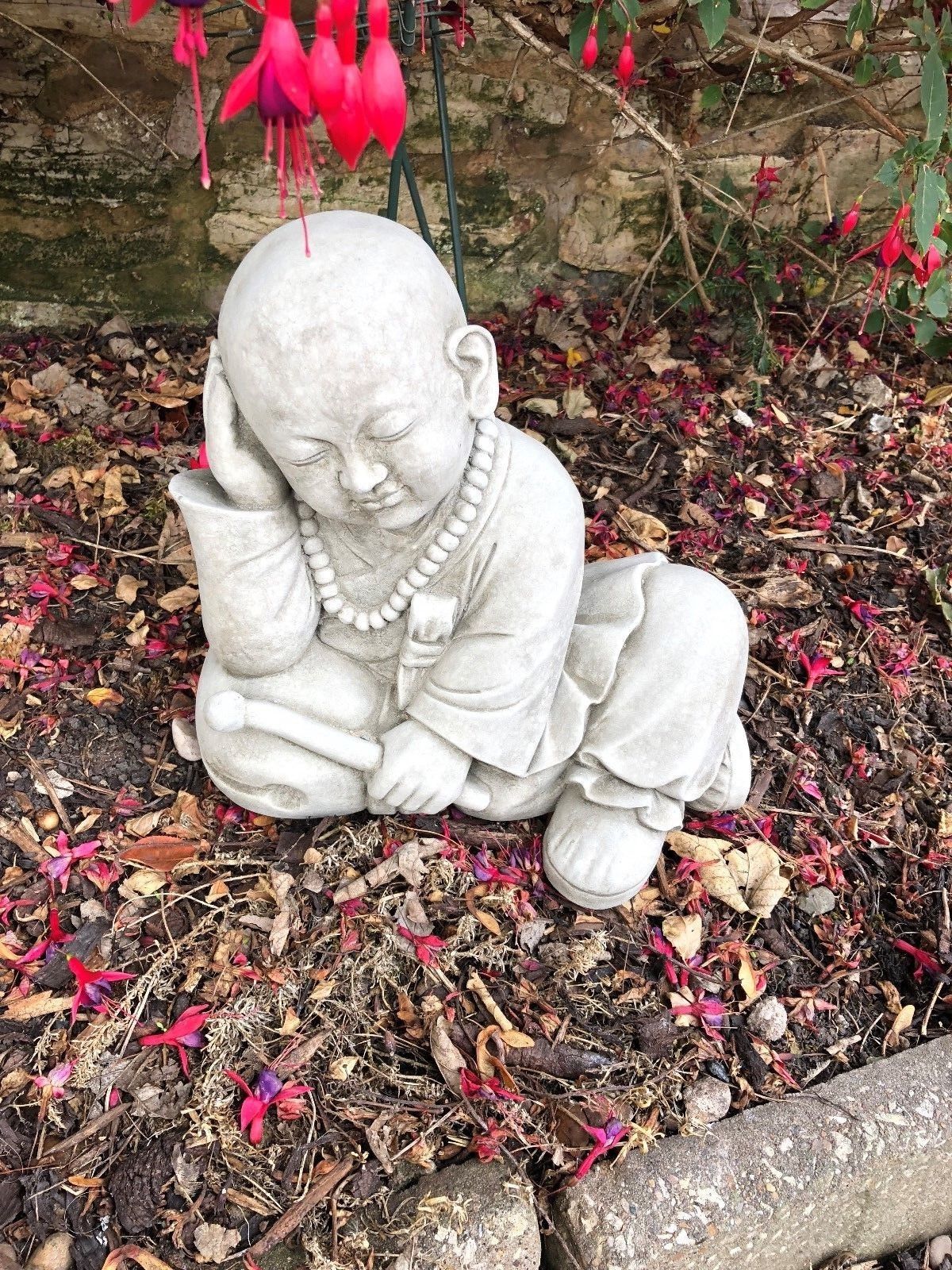 Stunning Stone Resting Monk Sculpture Garden Ornament with closed eyes and relaxed posture, crafted for outdoor use in spiritual garden themes.