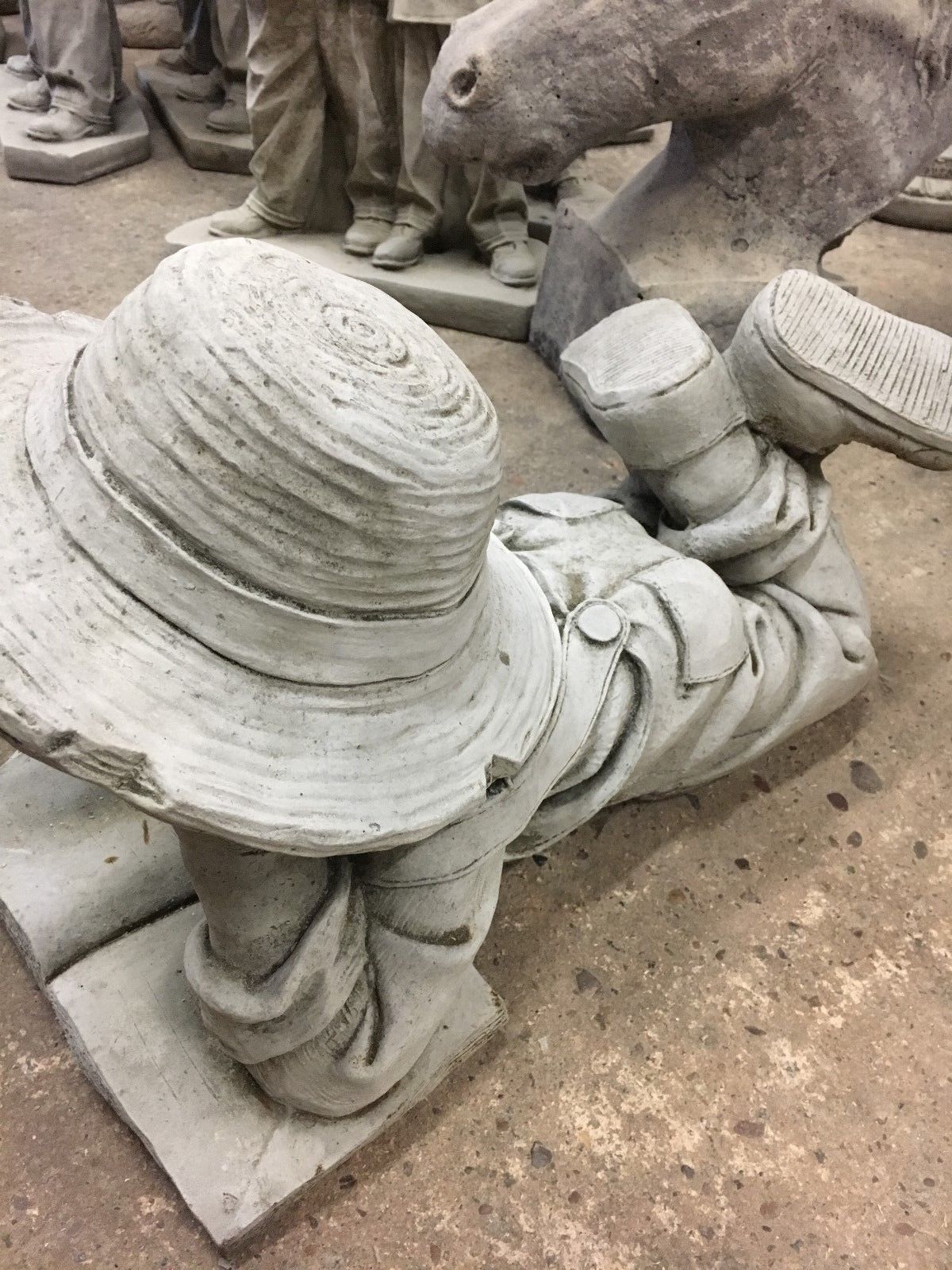 Side angle of Reading Boy Garden Statue in solid stone, emphasizing detailed hat and relaxed reading pose for patio decoration.