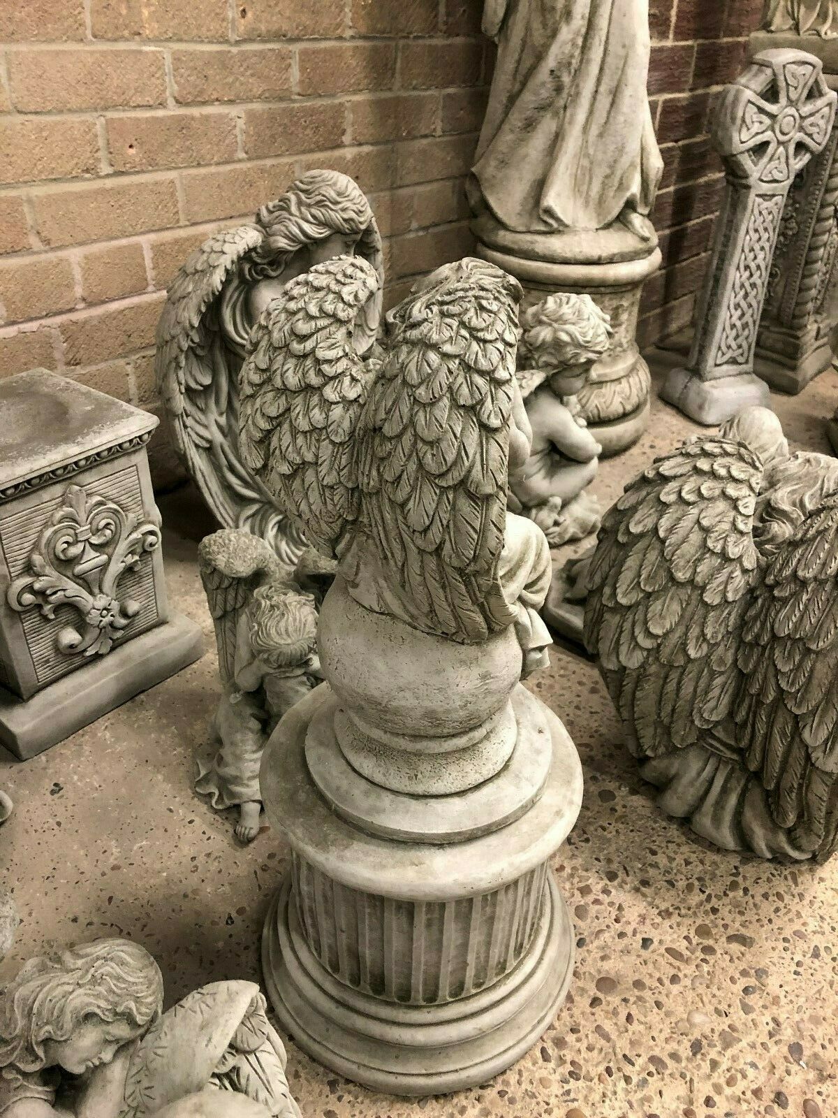 Rear view of Stone Angel Garden Statue - On Ball Plinth, highlighting detailed feathered wings and textured limestone finish.