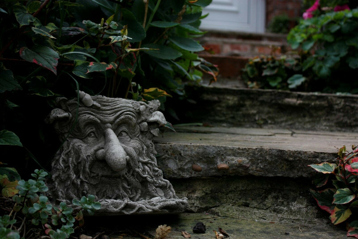 Solid Greenman Bird Feeder Stone Ornament placed on garden steps, blending with natural stone and greenery for decorative outdoor appeal.