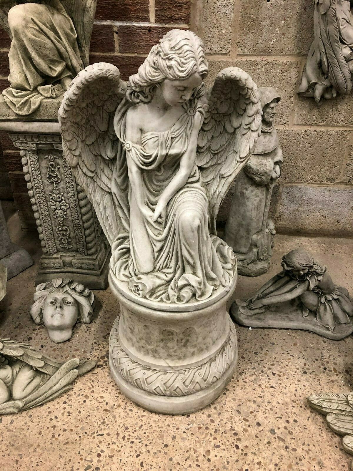 Front-facing Angel Garden Pedestal Statue - Stone Finish | Large & Durable. Features a kneeling angel with downcast gaze on a carved stone pedestal.