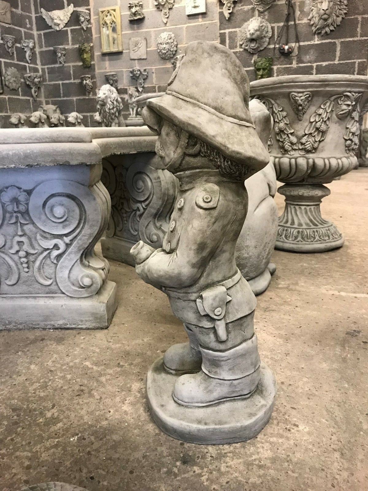 Profile of stone fireman garden sculpture with hose and buttons, made from solid limestone for durable lawn or balcony ornamentation.