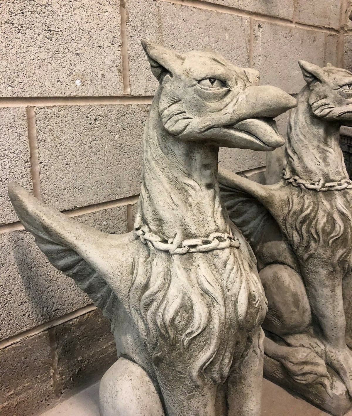 Detailed side angle of stone phoenix statue highlighting wing structure and chain detail, perfect for mythological garden themes.