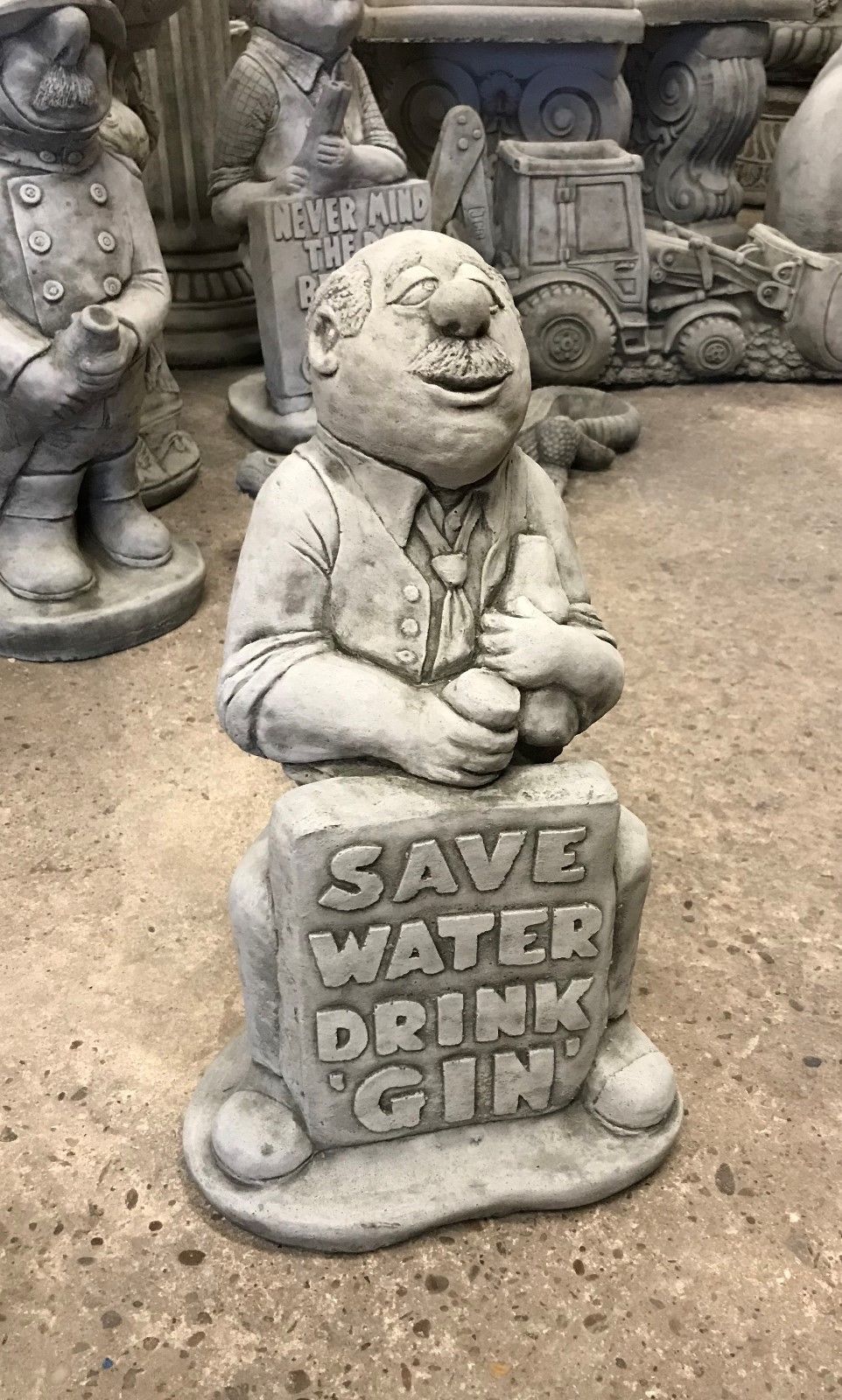 Side view of Stone Gin Man Garden Statue holding a bottle, featuring engraved 'Save Water Drink Gin' message in antique finish.