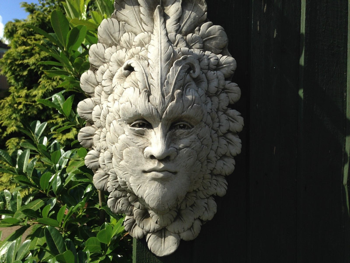 Close-up of Greenman Wall Plaque - Stone Feather Face showing detailed leaf and feather textures. Ideal for outdoor decorative wall art.