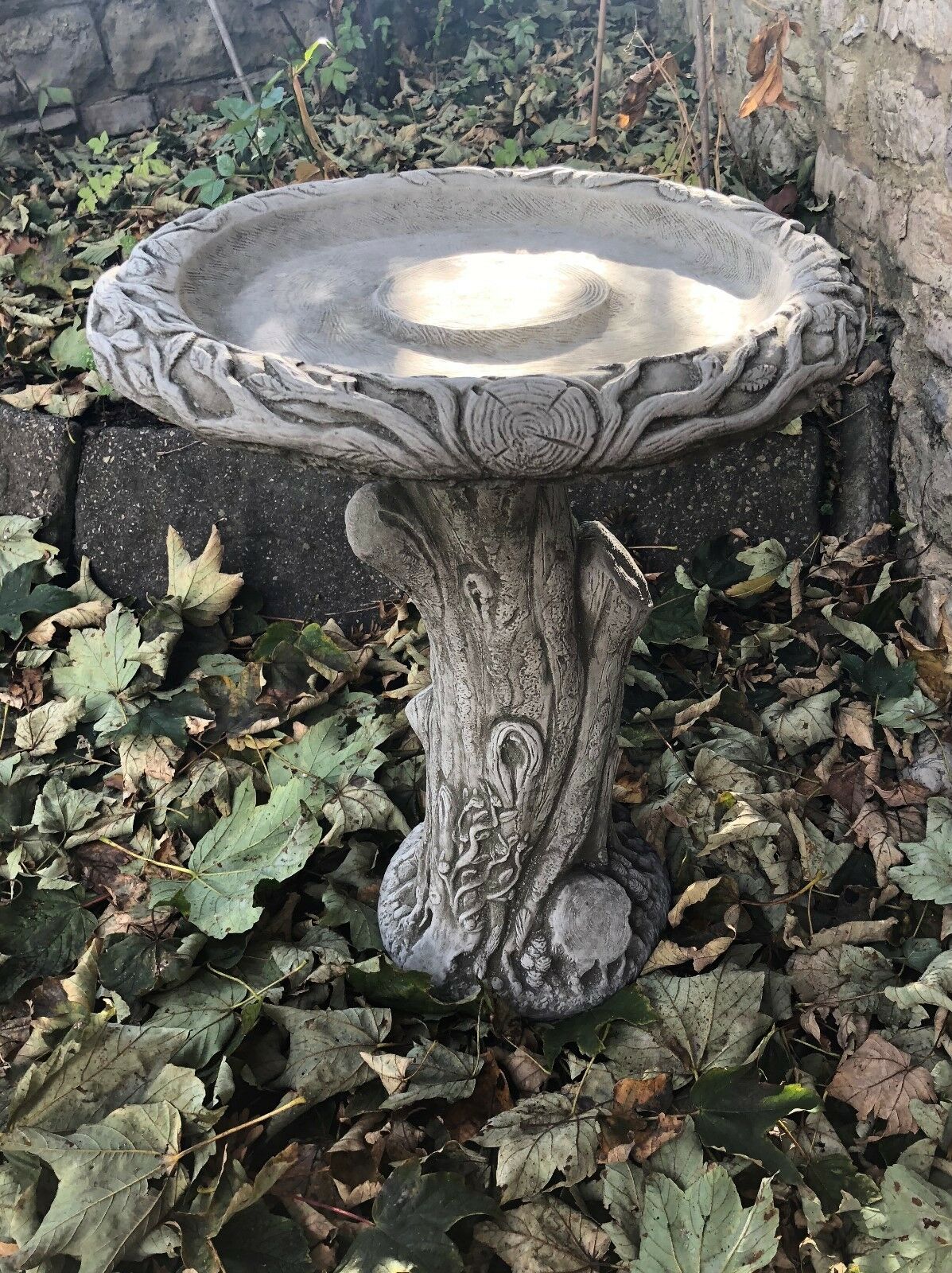 Decorative Tree Trunk Design Bird Bath in antique grey stone, handcrafted for outdoor use in gardens across the UK.