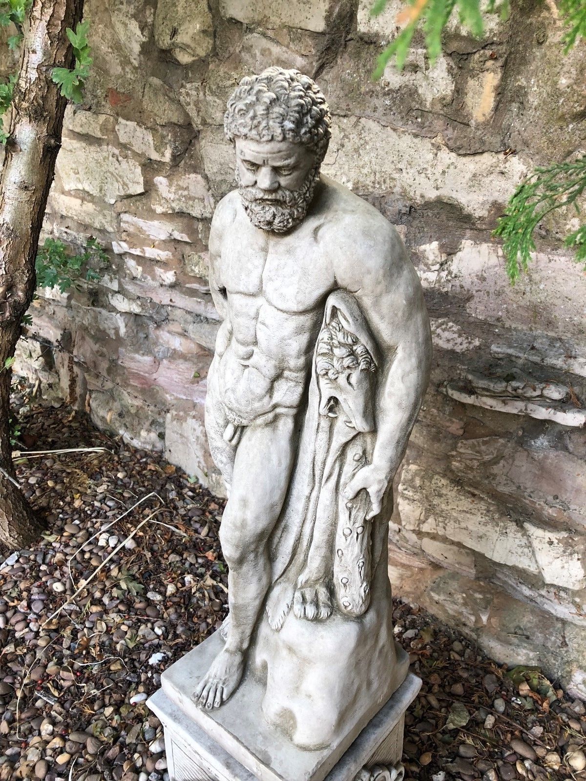 Top-down view of Hercules statue showing detailed torso and lion skin, crafted in antique grey limestone for outdoor decor.