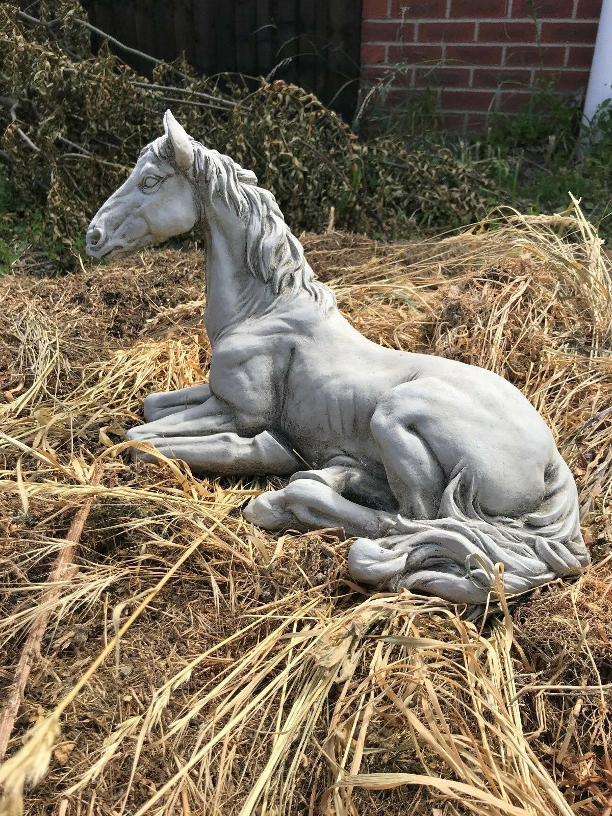 Side angle of Stone Resting Horse Statue - Garden Ornament showing intricate muscle definition and flowing mane design.