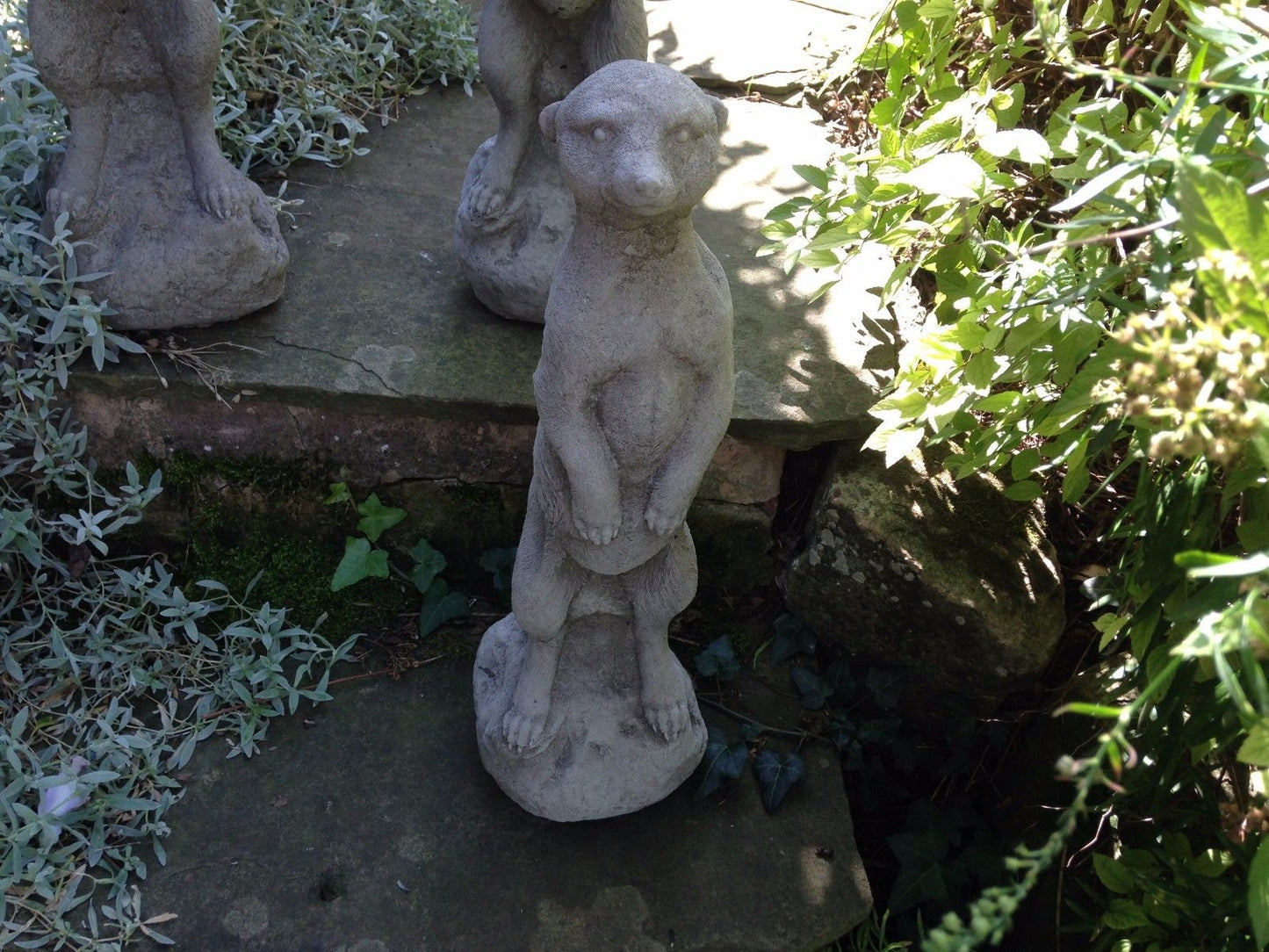 Close-up of a single stone meerkat ornament with detailed texture, ideal for weather-resistant garden decoration.