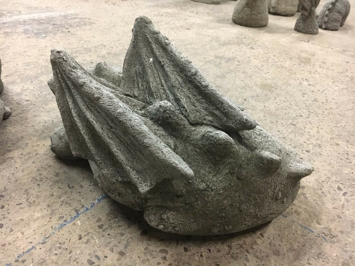 Rear view of sleeping baby dragon statue showing detailed stone wings and textured back, suitable for garden or balcony decoration.