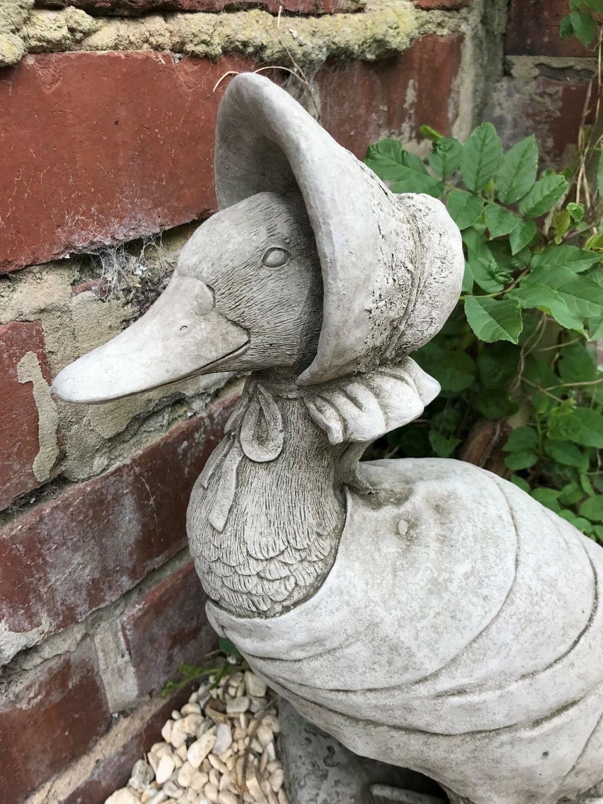 Close-up of Jemima Duck garden statue showing bonnet and feather texture. Crafted from weather-resistant limestone for outdoor use.