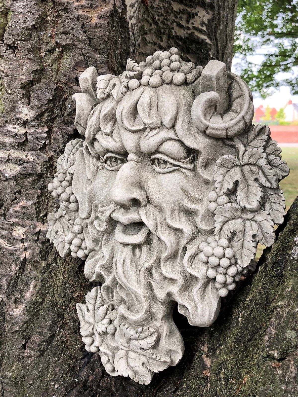 Angled view of Bacchus Face Garden Plaque in antique stone, featuring mythological design and ideal for outdoor wall hanging in home gardens.
