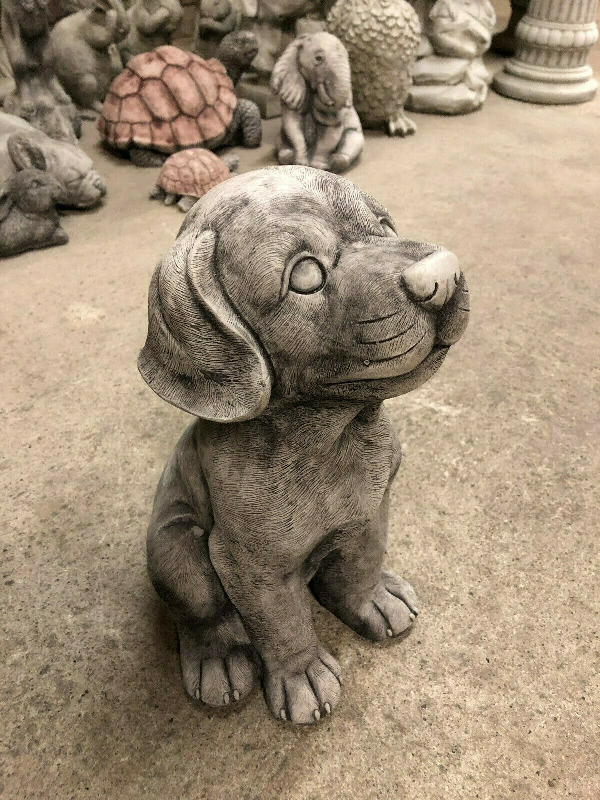 Three-quarter view of stone puppy garden ornament with expressive face and antique grey finish. Enhances outdoor spaces with charm and durability.