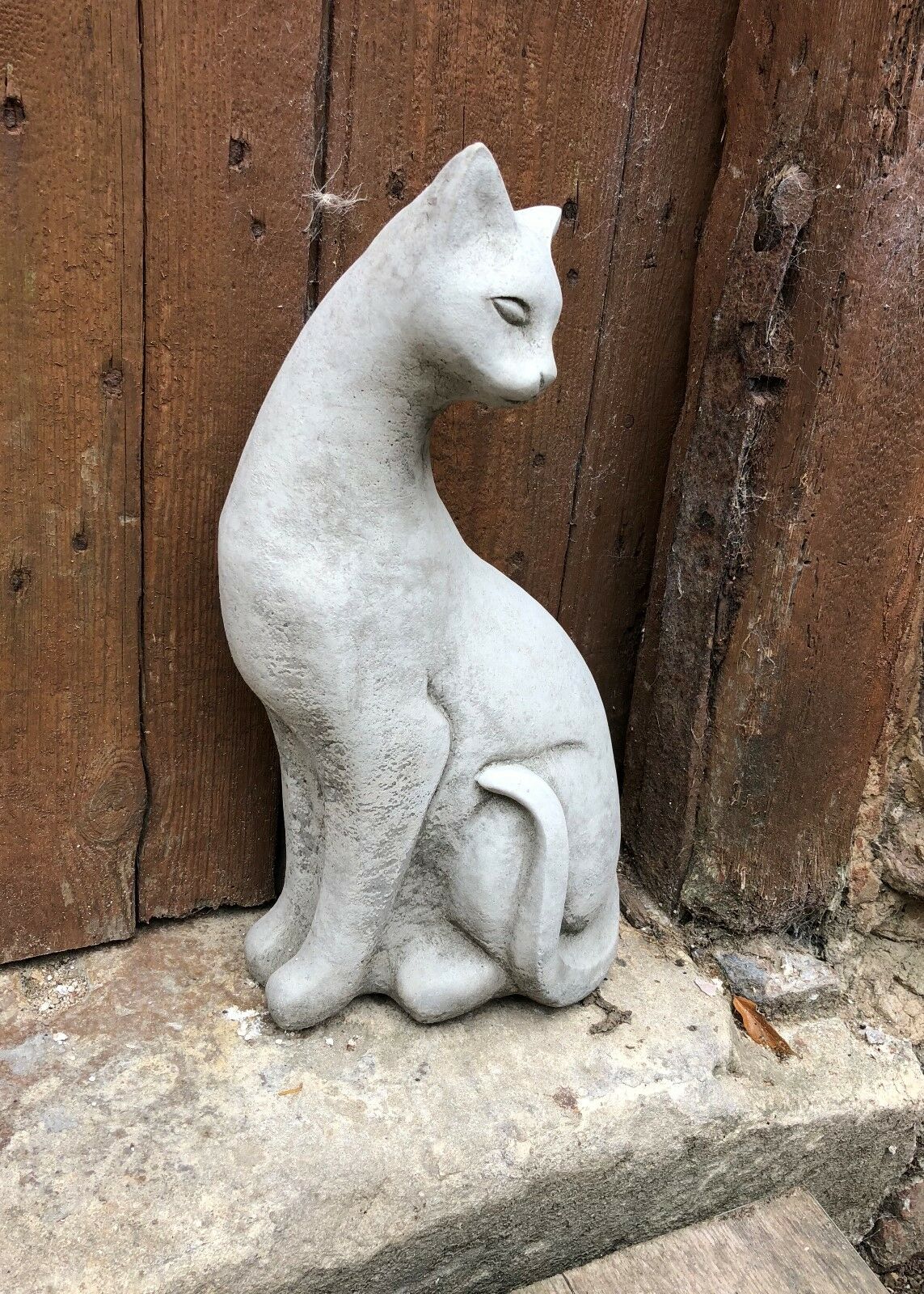 Right-facing stone Siamese cat statue with curved tail and upright posture, ideal for garden or lawn ornamentation.