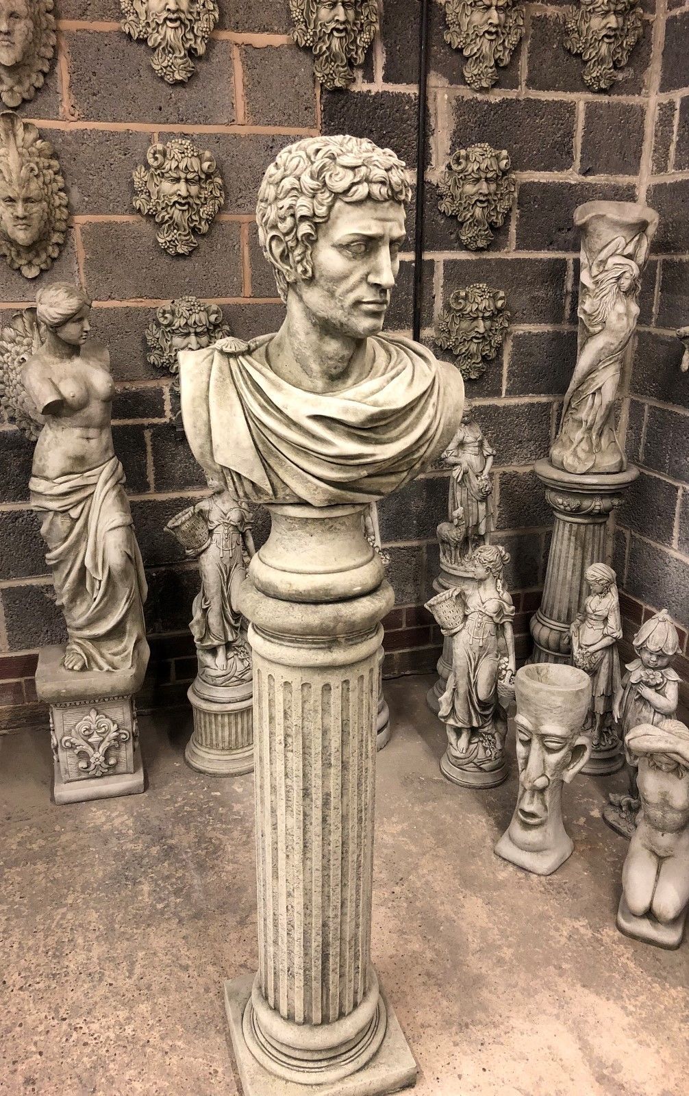 Side angle of Stone Marc Anthony Bust Statue on limestone pillar, showcasing intricate Roman design for elegant garden or patio decor.