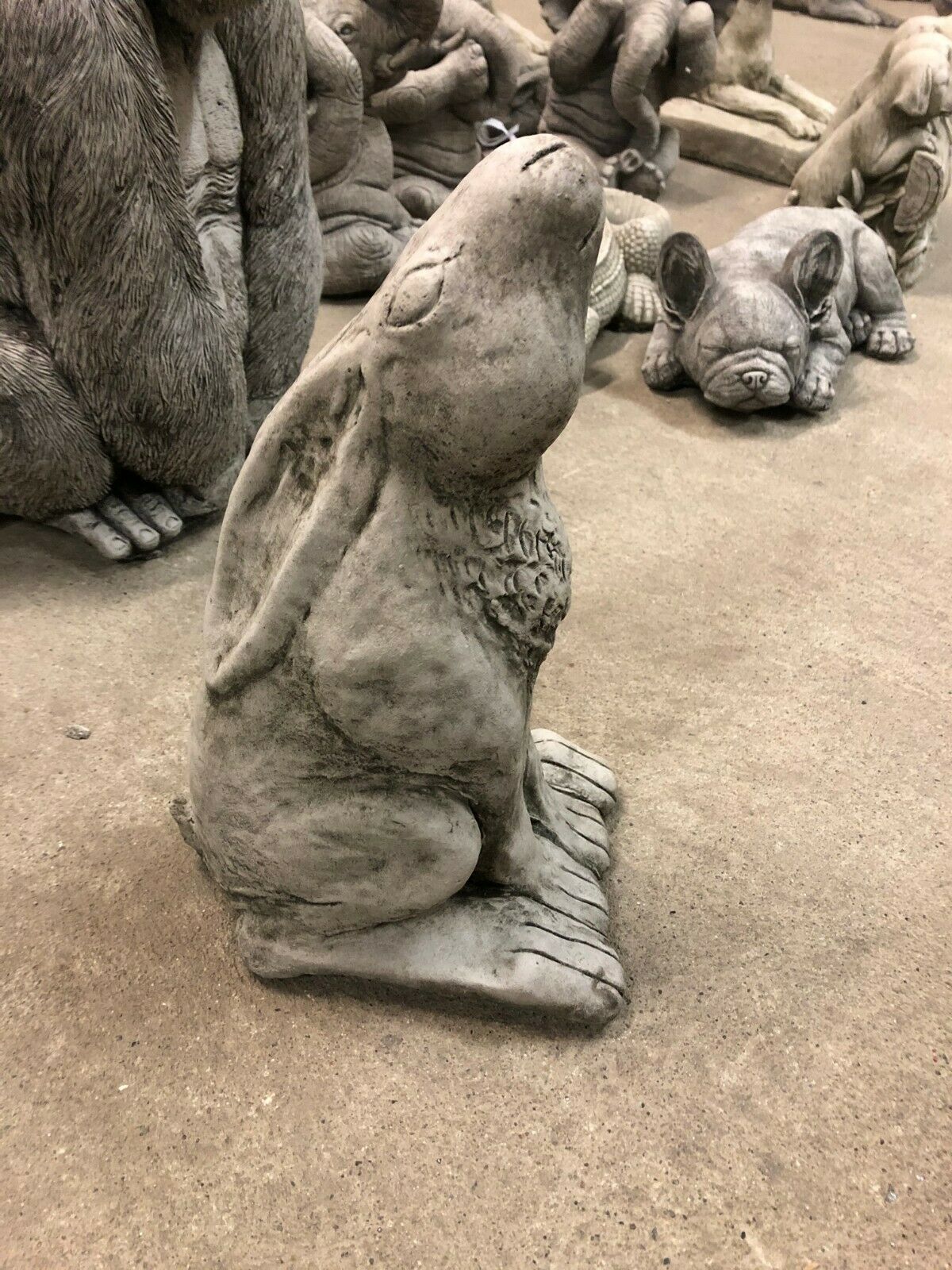 Side profile of the Moongazing Hare Stone Statue with upward gaze, showcasing its lifelike design and rustic stone finish for garden decoration.
