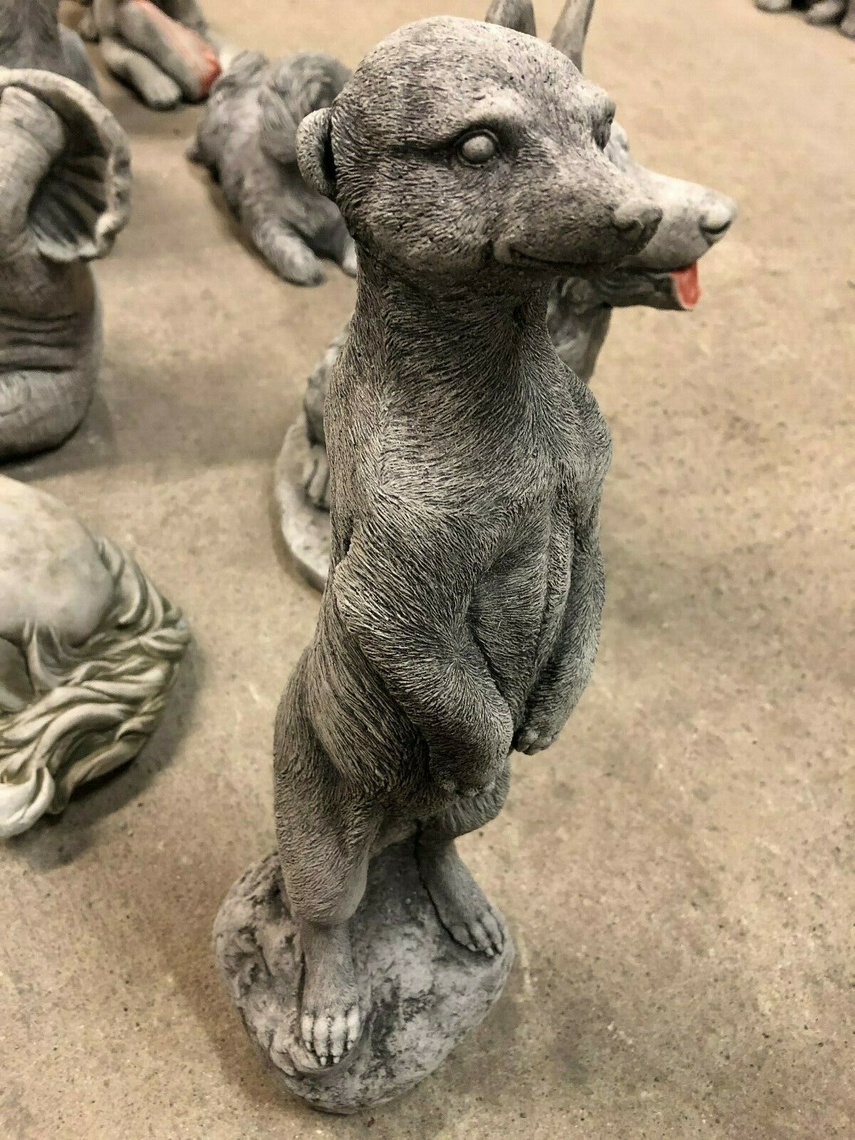 Front view of a stone meerkat statue with lifelike features, designed for outdoor garden decoration in all weather.