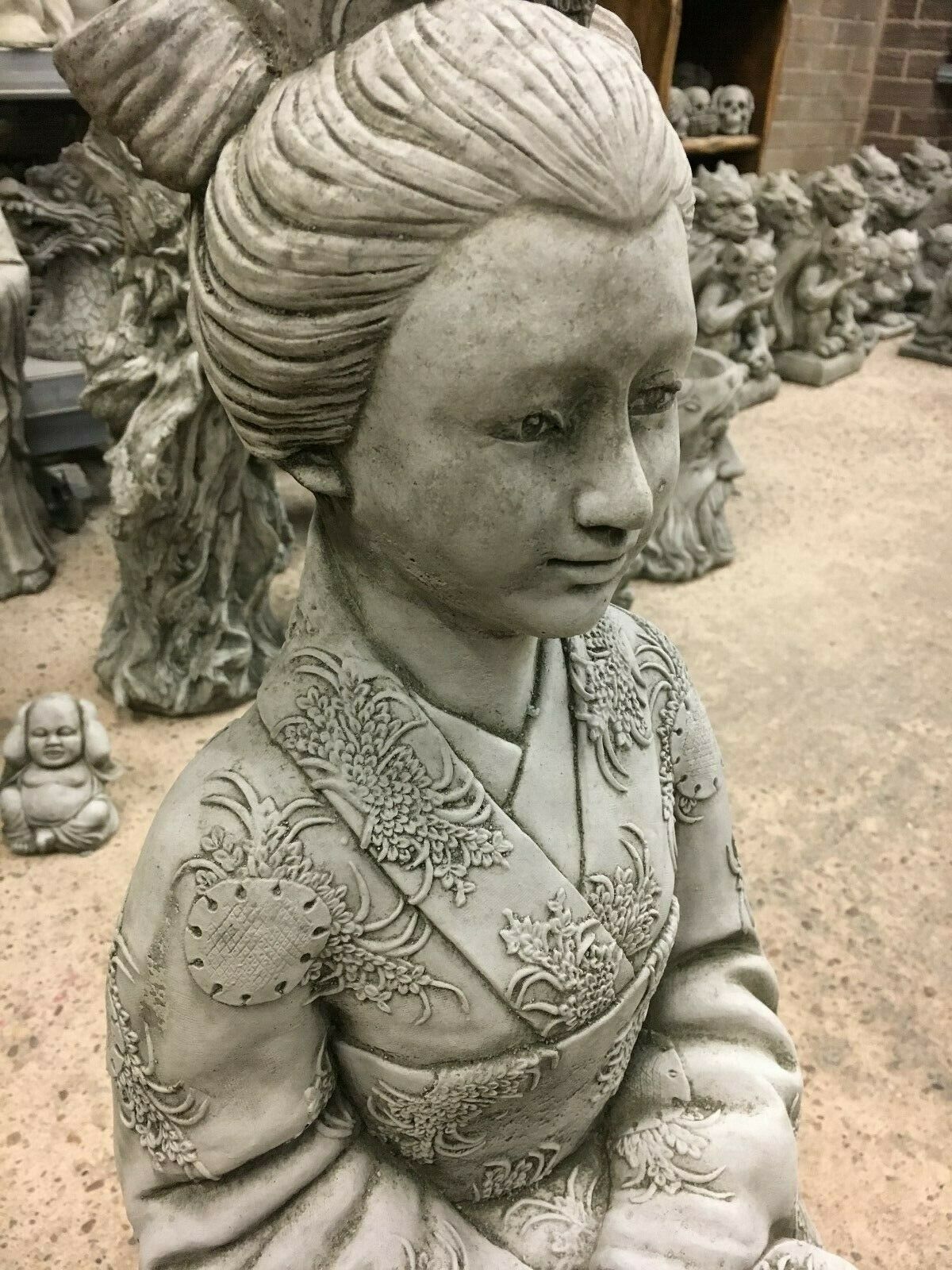 Close-up of Stone Kneeling Geisha Lady Statue highlighting facial features and kimono detail, perfect for decorative garden settings.