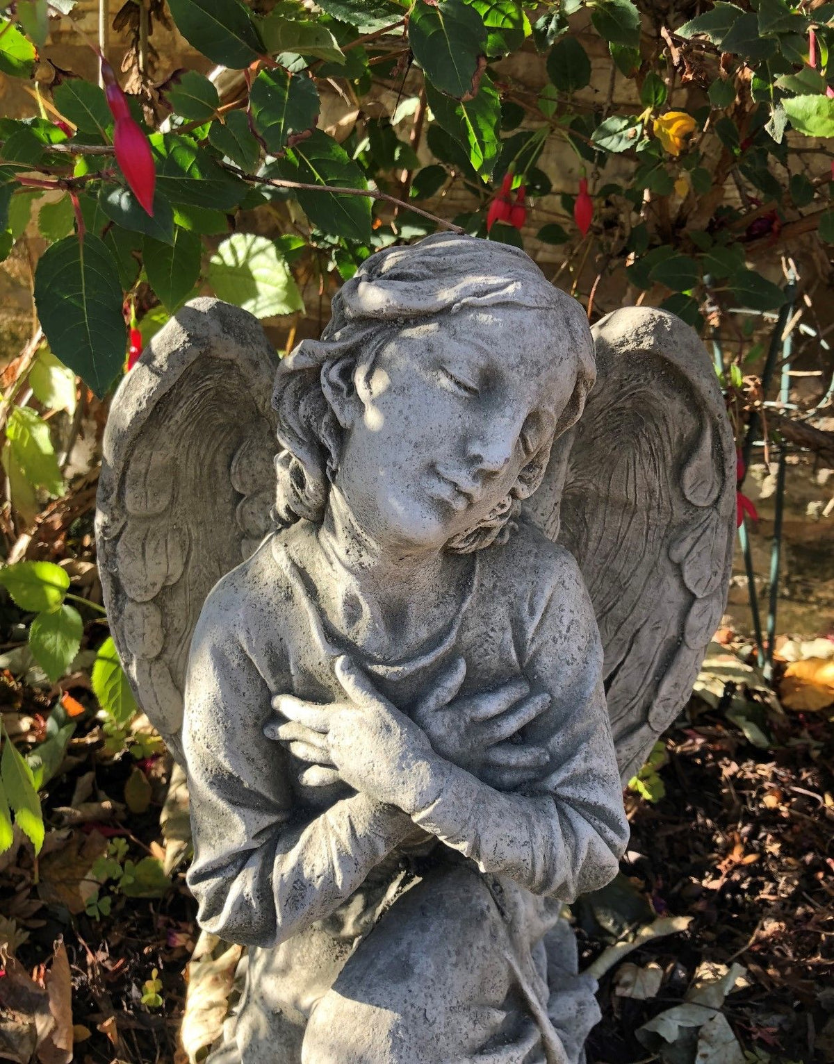 Close-up of Angel Garden Statue - Stone Kneeling Arms Crossed showing intricate facial features and craftsmanship, perfect for spiritual garden spaces.