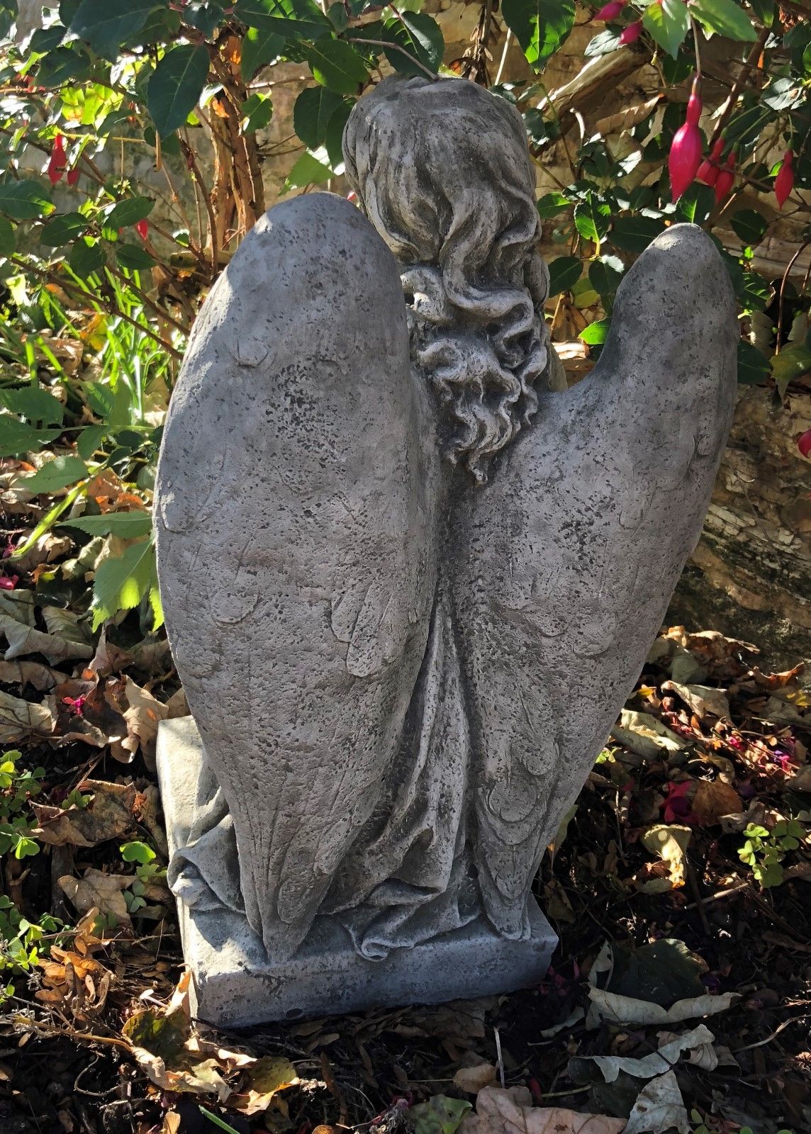 Rear view of Stone Kneeling Angel Garden Statue highlighting detailed feathered wings and textured limestone finish for lasting outdoor elegance.