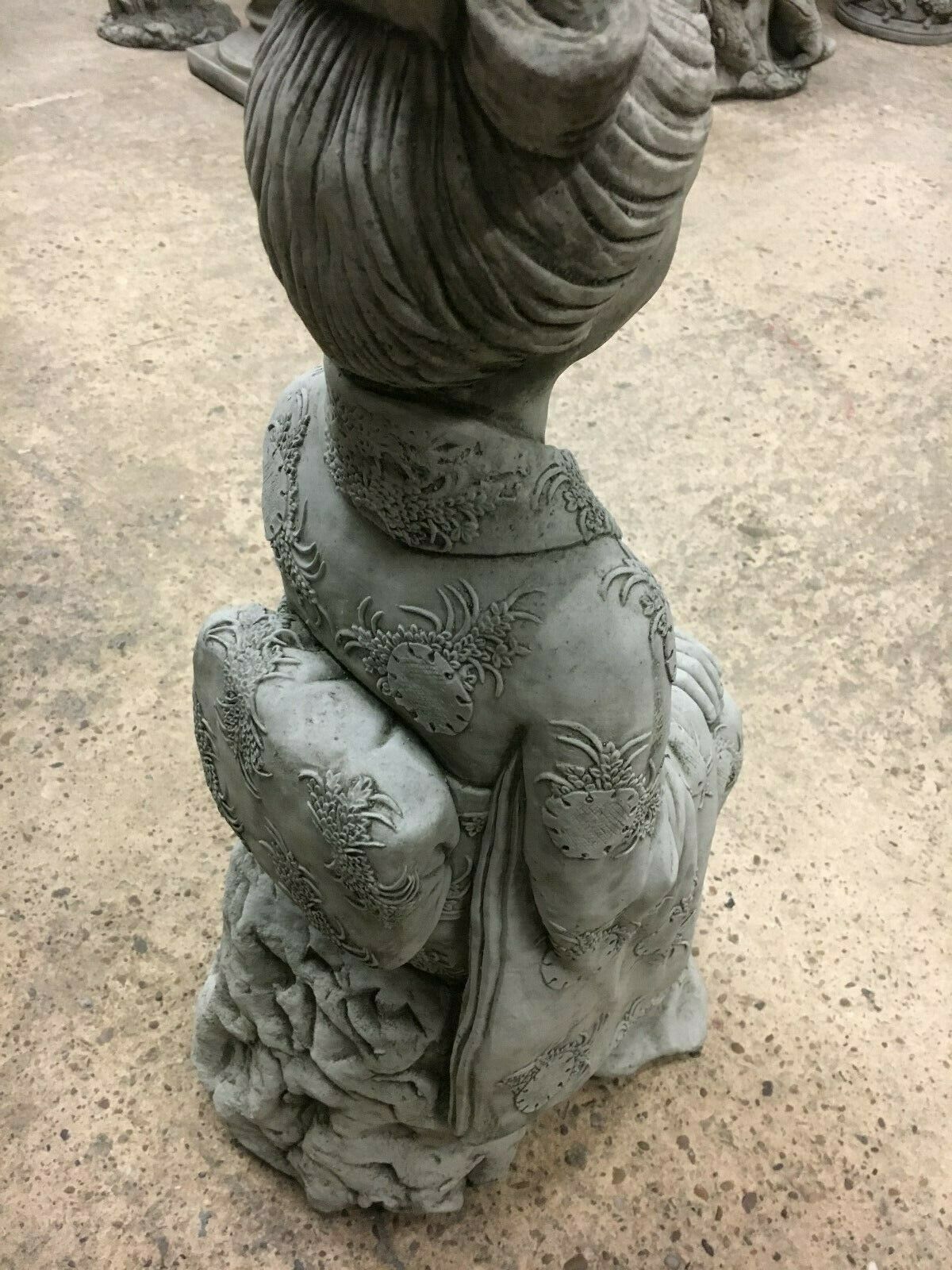 Angled back view of Stone Kneeling Geisha Lady Statue emphasizing textured limestone and ornamental kimono pattern.