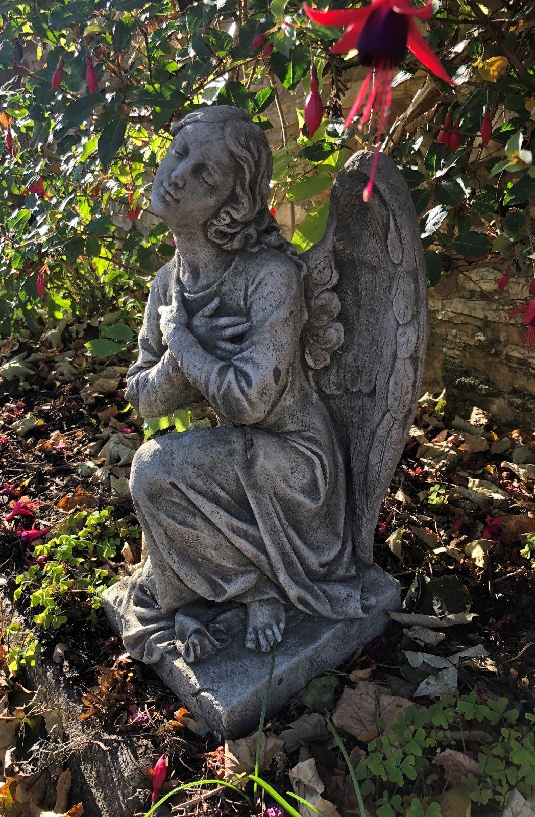 Stone Kneeling Angel Garden Statue with Arms Crossed facing upward in a peaceful pose, enhancing garden ambiance with spiritual charm.