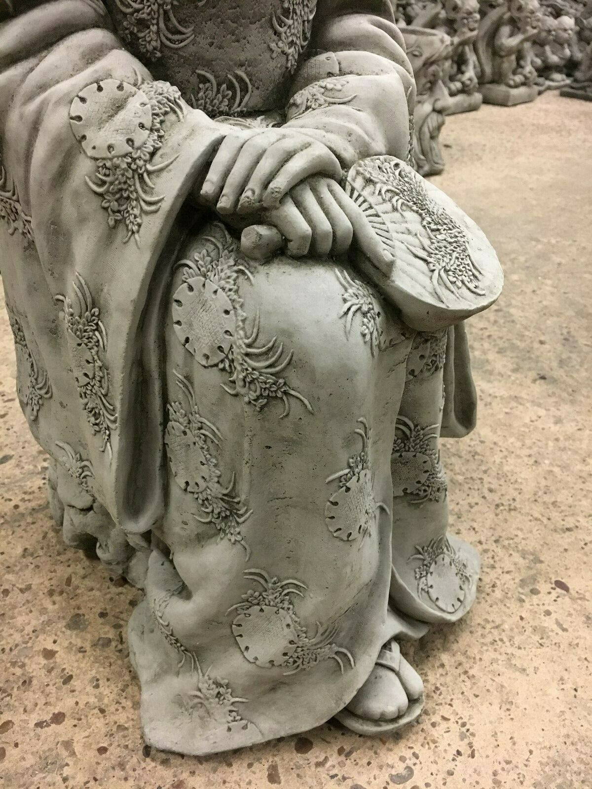 Detailed view of Stone Kneeling Geisha Lady Statue's hands holding a fan, showcasing fine craftsmanship for garden sculpture lovers.