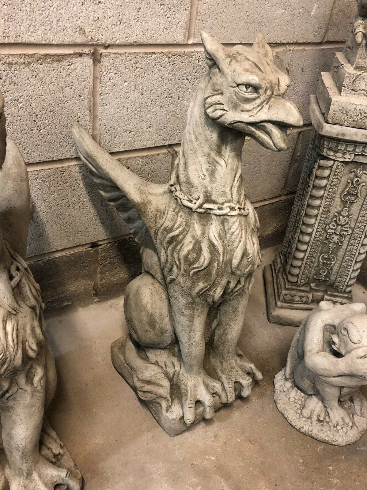 Phoenix statue with wings and chain detail, part of a decorative stone guardian pair for garden or patio ornamentation.