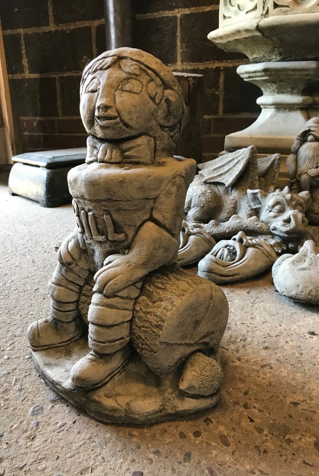 Angled view of the Stone Bill statue showing its detailed facial features and woodland-themed base, suited for lawn ornamentation.