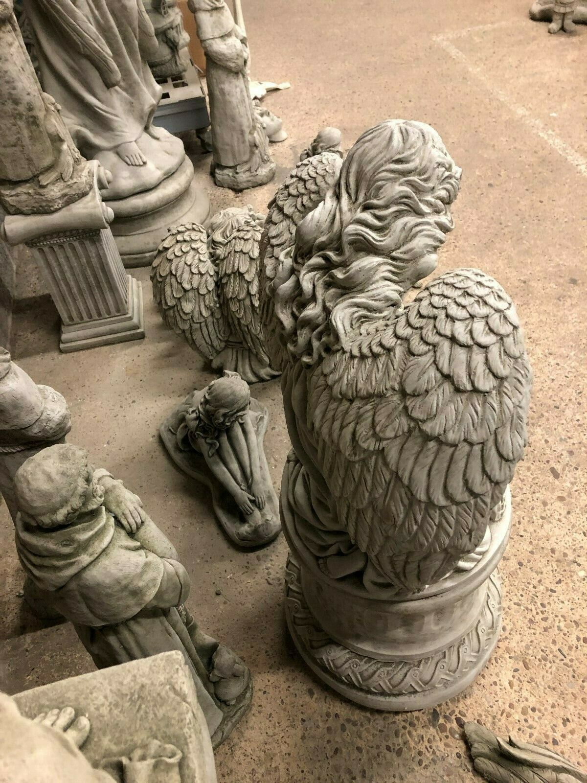 Rear angle of Angel Garden Pedestal Statue - Stone Finish | Large & Durable. Displays detailed feathered wings and sculpted hair from behind.