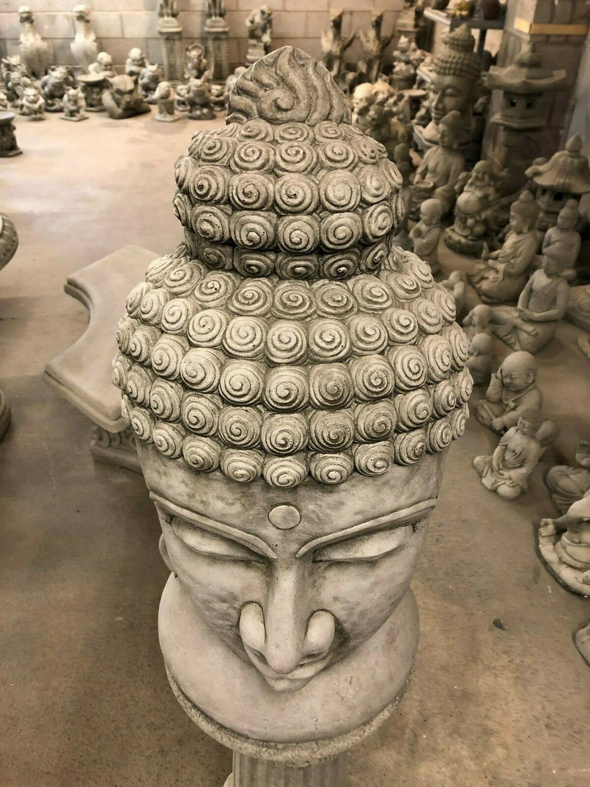 Top-down view of Buddha Head Garden Statue highlighting intricate spiral hair design. Unique stone ornament for zen-inspired gardens.