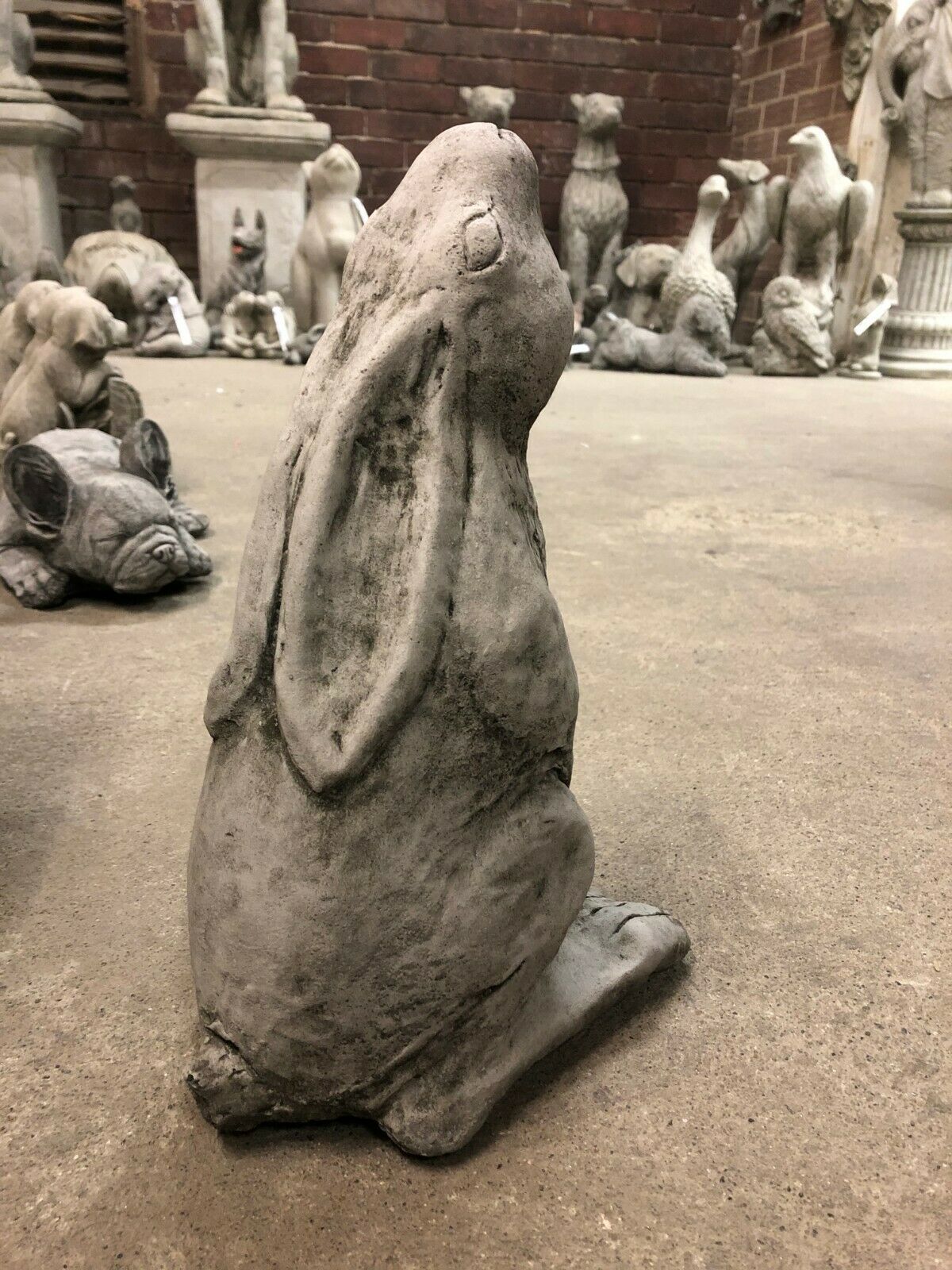 Rear view of the Moongazing Hare Stone Statue highlighting its long ears and smooth stone texture, ideal for patios or flowerbeds.