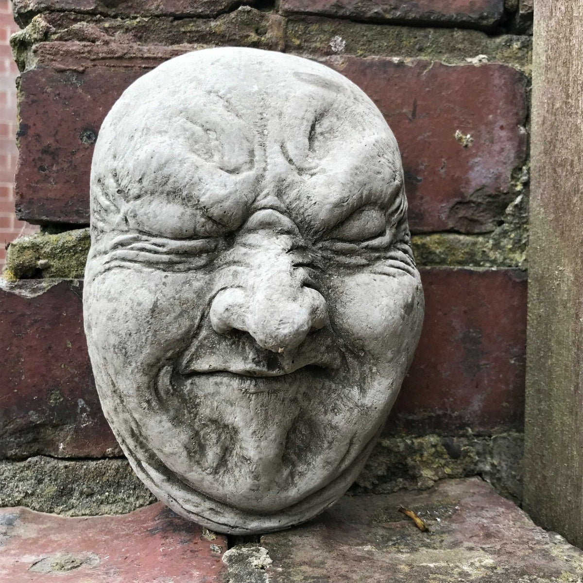 Funny Stone Garden Plaque - Garden Wall Plaque with gurning face design, made of weather-resistant limestone for outdoor decor.