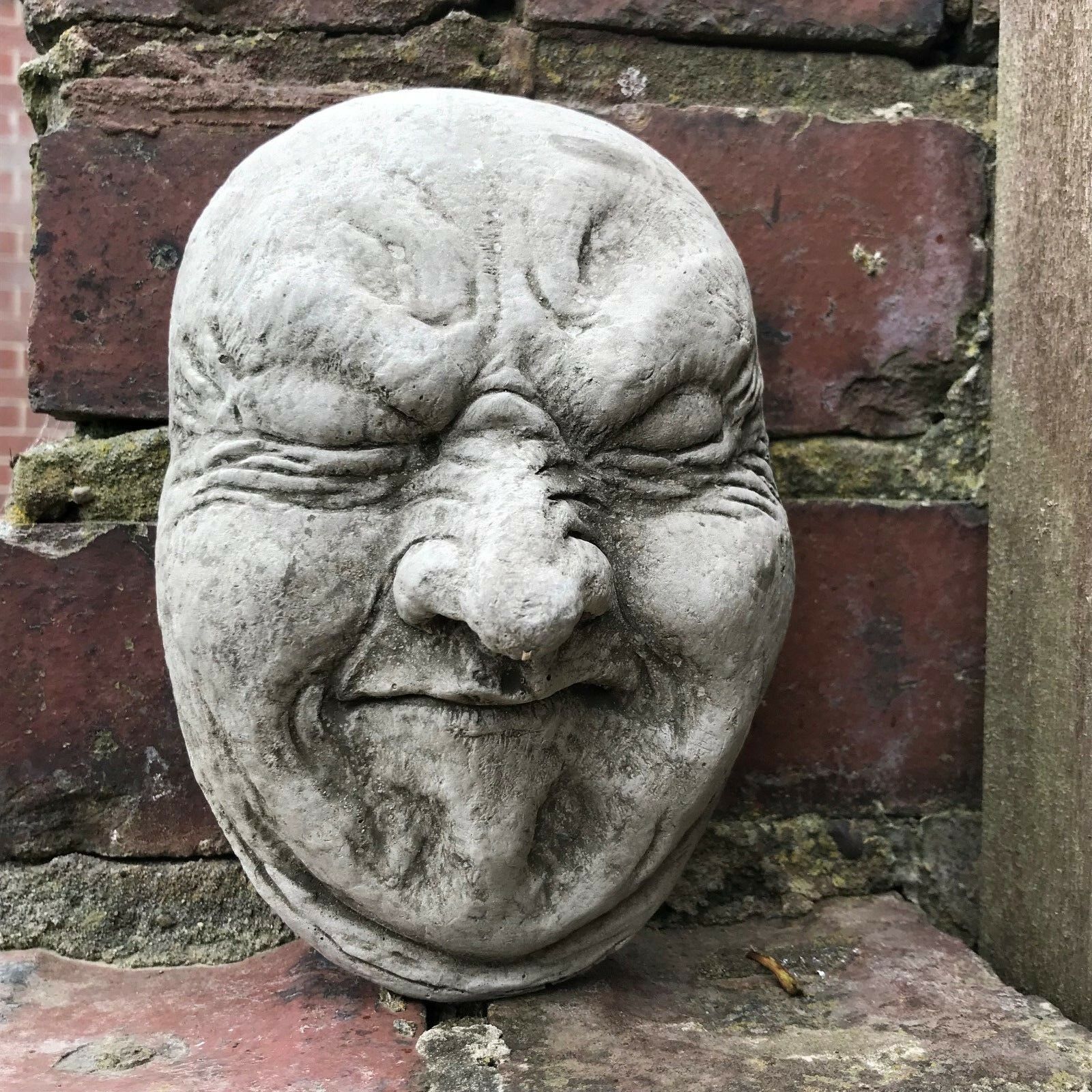 Funny Stone Garden Plaque - Garden Wall Plaque with gurning face design, made of weather-resistant limestone for outdoor decor.