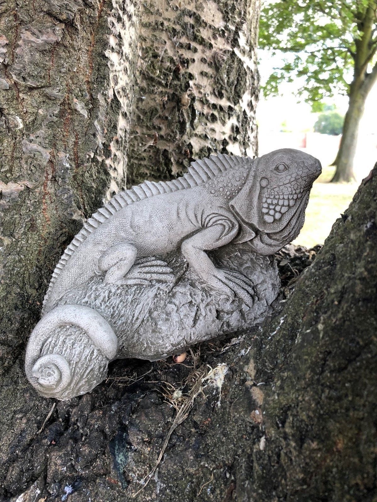 Curled-tailed iguana sculpture from the Stone Garden Ornaments Collection positioned in tree bark, crafted from frost-resistant limestone.