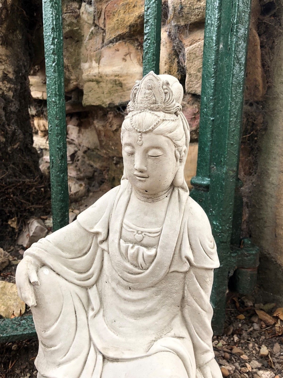 Close-up of Kuan Yin garden statue's upper body and serene facial features. Handcrafted limestone ornament for tranquil garden décor.
