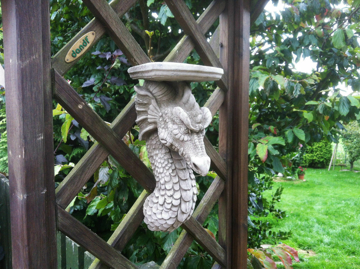 Dragon Garden Wall Shelf in antique stone finish attached to lattice panel. Decorative plaque for garden or patio with mythical design.